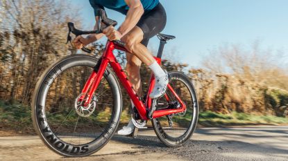 Image shows cyclist riding deep section carbon wheels